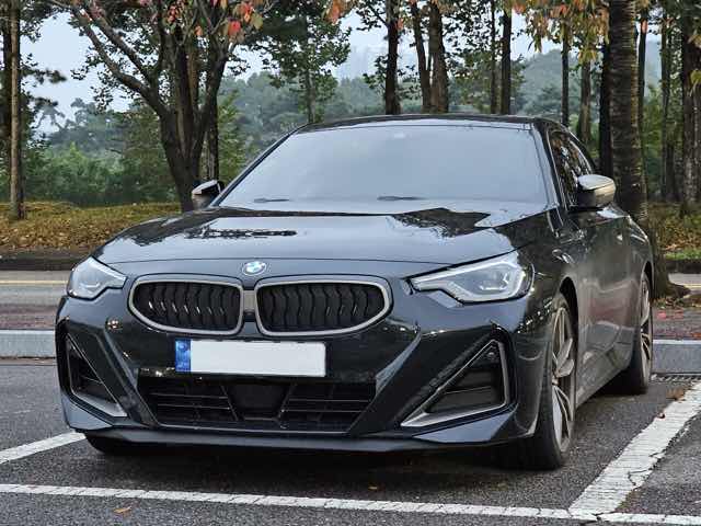 Front three-quarter view of a black 2023 BMW M240i xDrive coupe