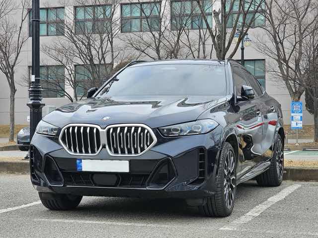 Front three-quarter view of a black 2024 BMW X6 xDrive40i